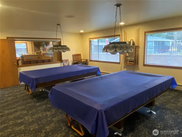a living room with furniture a pool table and a fireplace