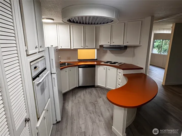 a kitchen with stainless steel appliances a stove a sink a refrigerator and cabinets