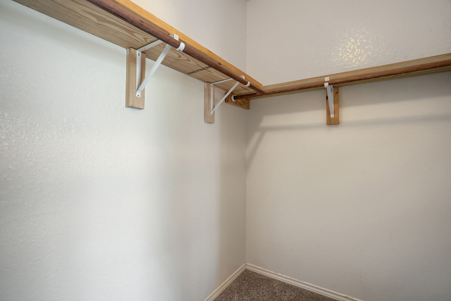 2420 Ranger Pass Seguin, TX 78155 - Photo 17 of 28 Walk-in closet featuring a corner configuration with wood-finish shelving and hanging rods
