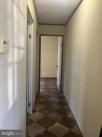 a view of a hallway with wooden floor and entryway