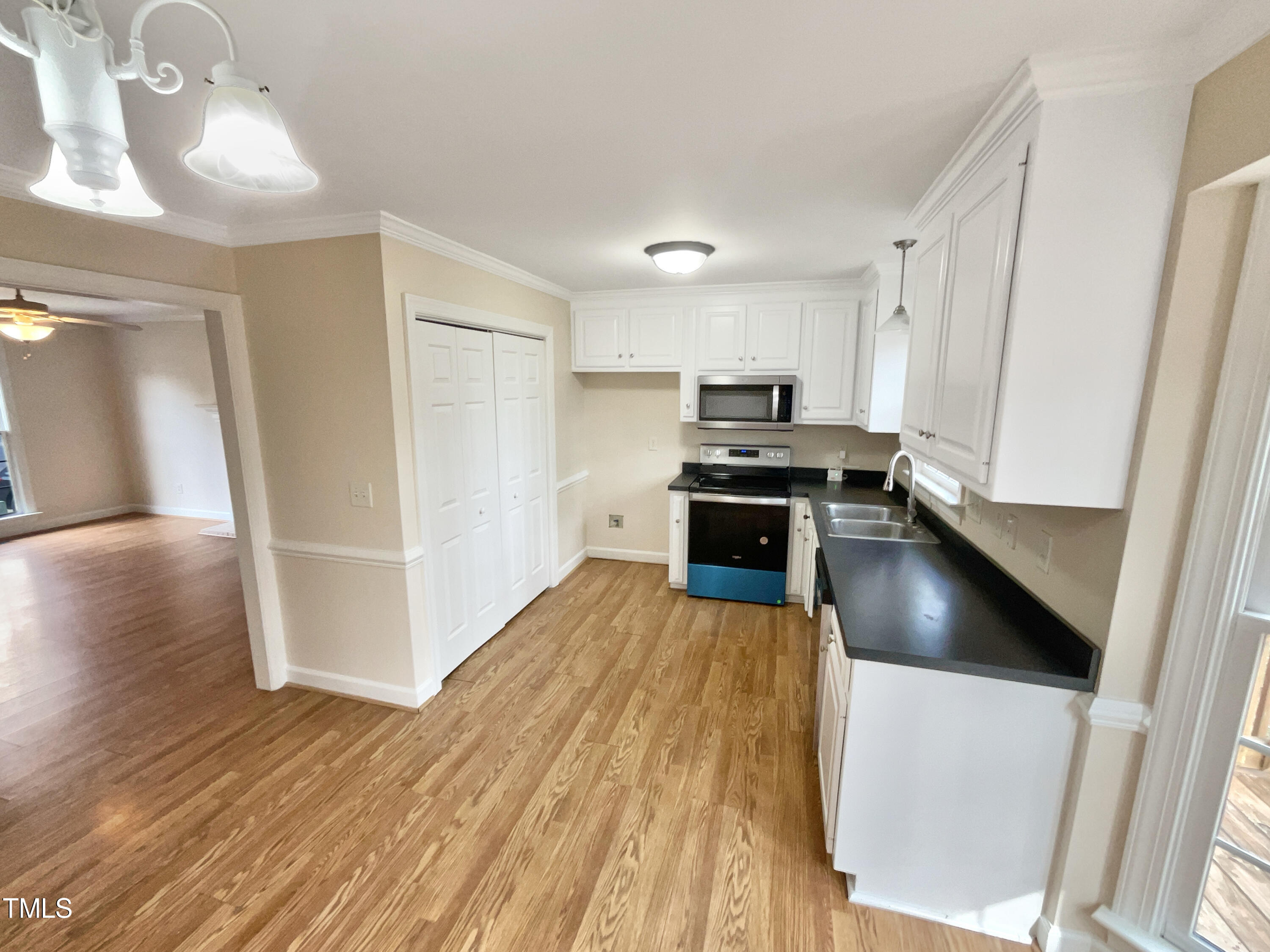 7212 Ewing Place Raleigh, NC 27616 - Photo 8 of 19 a kitchen with wooden floors and stainless steel appliances