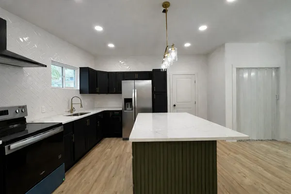 a kitchen with a sink a counter space and cabinets
