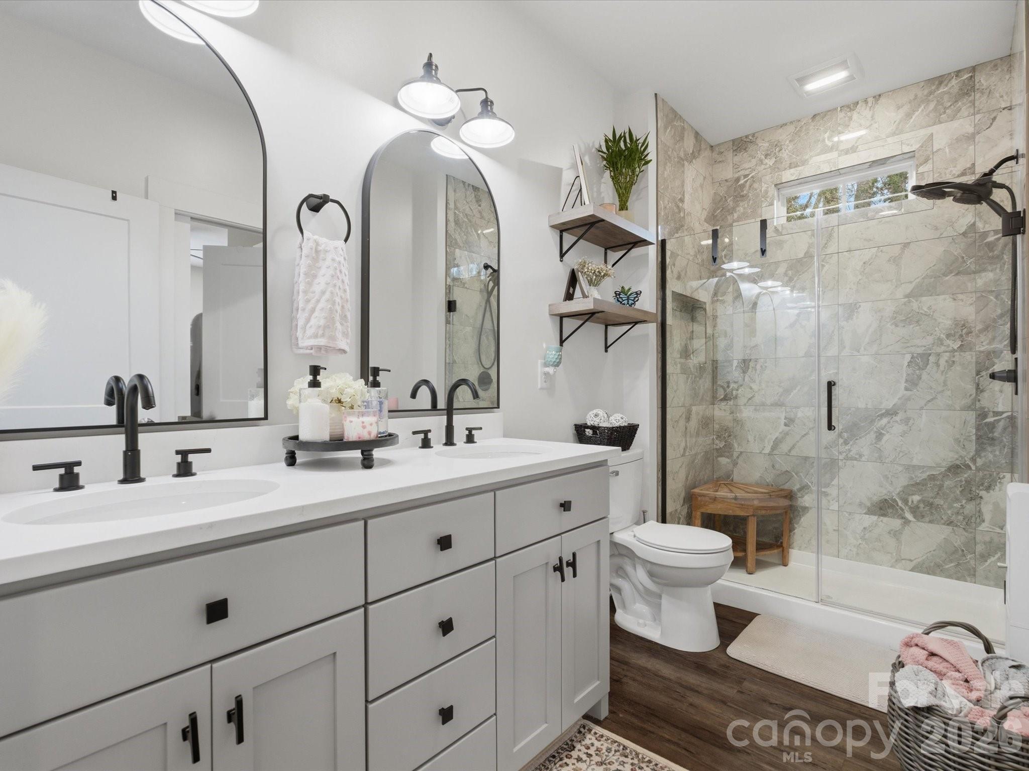 562 Lake Head Road Norwood, NC 28128 - Photo 11 of 43 a bathroom with a double vanity sink toilet and shower