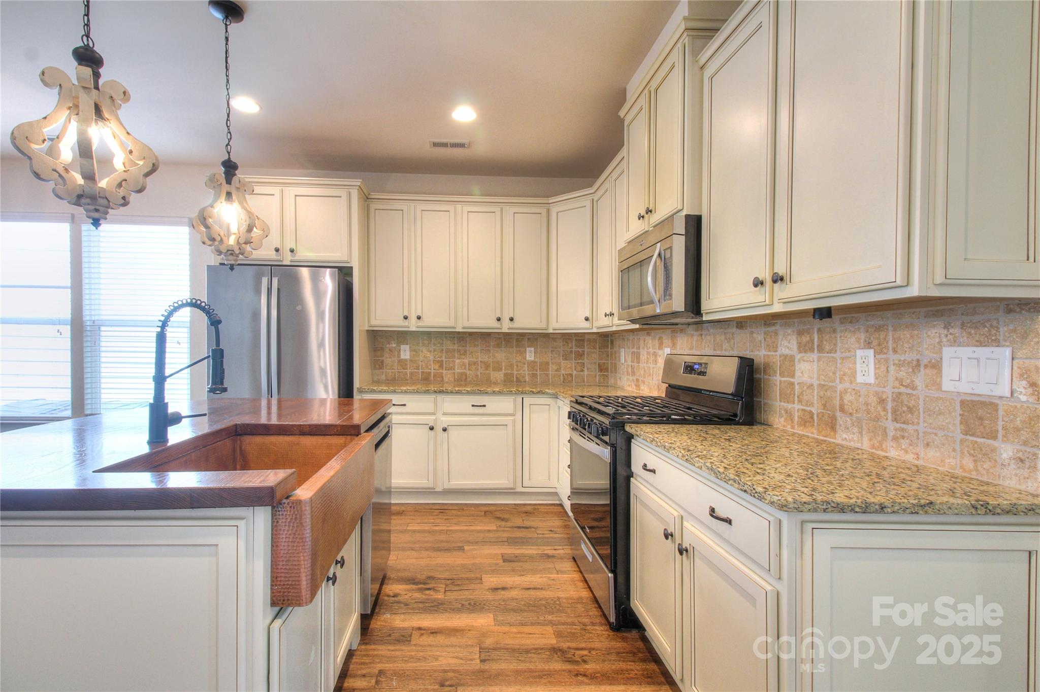 1012 Equipoise Drive Indian Trail, NC 28079 - Photo 5 of 31 a kitchen with stainless steel appliances granite countertop a sink stove and refrigerator