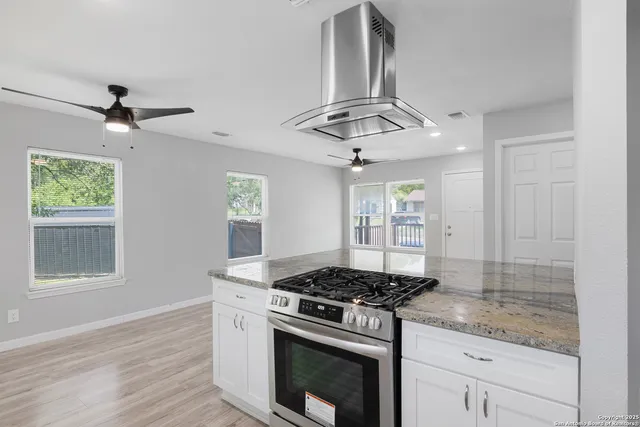 a kitchen with stainless steel appliances granite countertop a stove a sink and a window