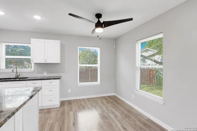 a open kitchen with granite countertop a stove and a wooden floors