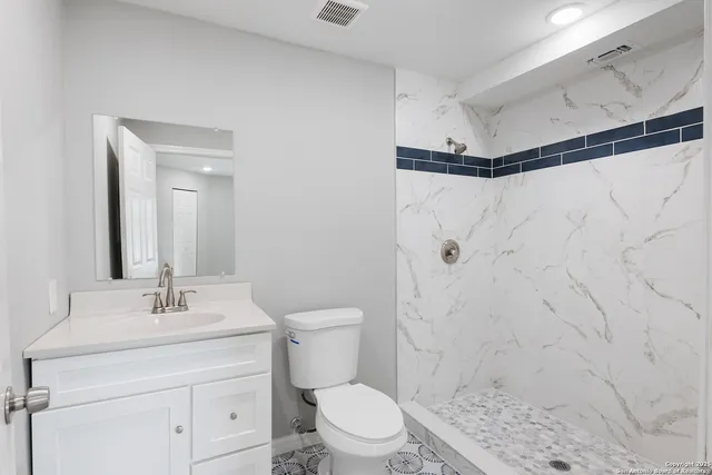 a bathroom with a sink a toilet and shower