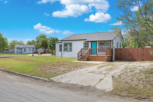a view of a house with a backyard and a tree