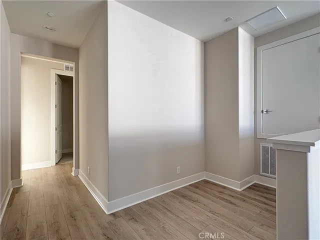 an empty room with wooden floor and closet