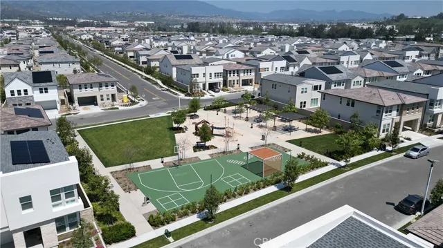 an aerial view of residential houses with outdoor space and parking