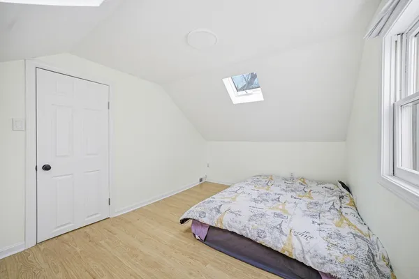 a view of a hallway with wooden floor and a potted plant