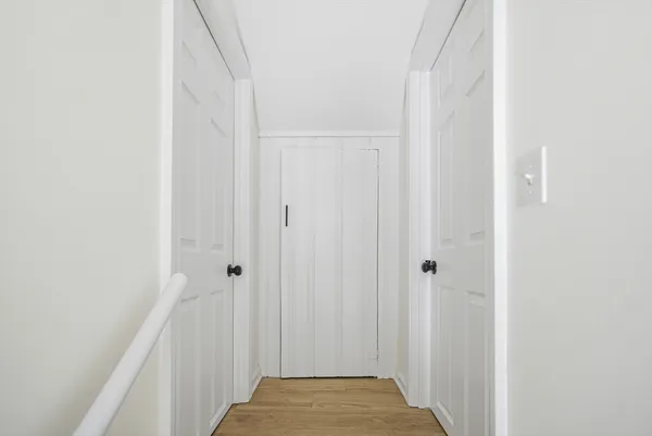 an empty room with wooden floor and white walls
