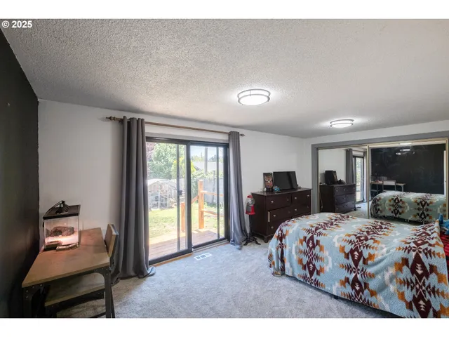 a bedroom with a bed and large windows