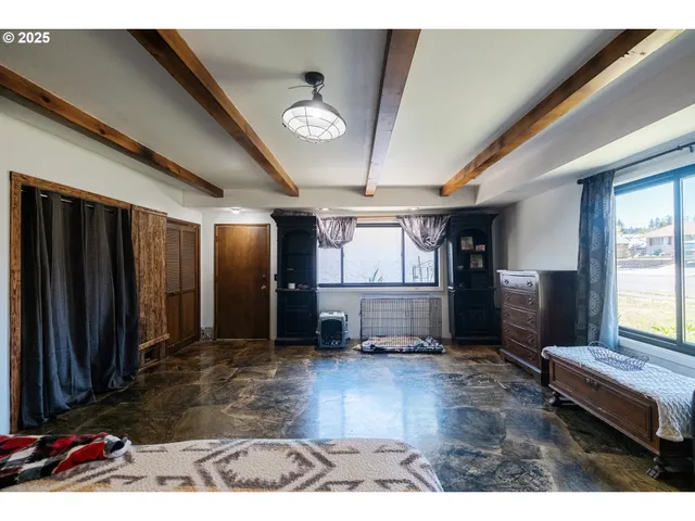 a living room with stainless steel appliances kitchen island granite countertop furniture a rug and a large window