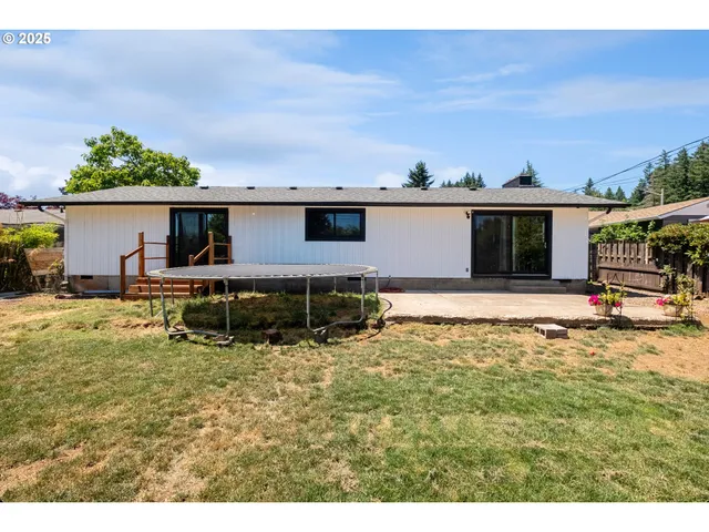 a backyard of a house with table and chairs