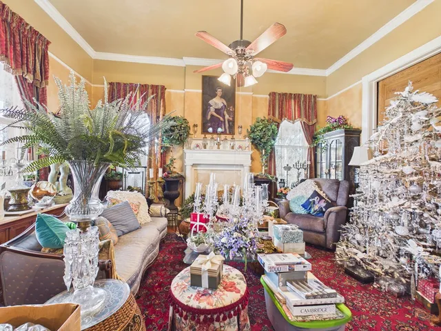 a living room with furniture a large window and a chandelier