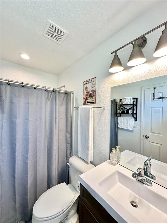 2120 Southwest 142nd Court Road Ocala, FL 34481 - Photo 14 of 14 a bathroom with a sink a toilet a mirror and shower curtain