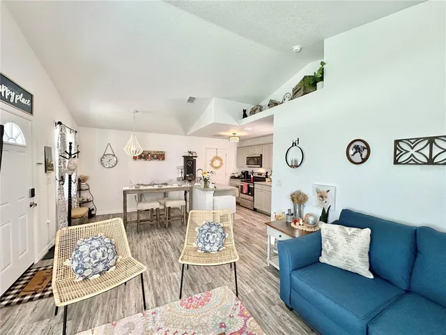 a living room with furniture kitchen view and a table