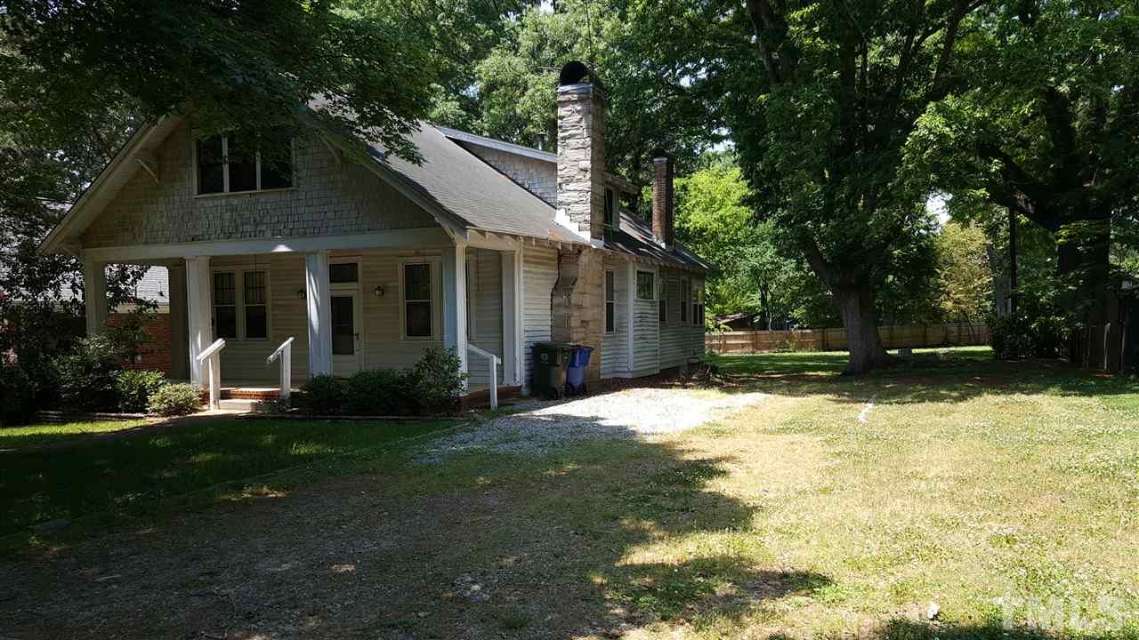 508 Burton Street Raleigh, NC 27608 - Photo 3 of 25 a view of a white house with a yard potted plants and large tree
