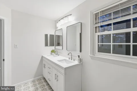 a bathroom with a double vanity sink and a mirror