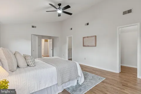 a bedroom with a large bed and wooden floor