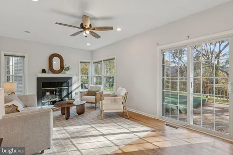 a living room with furniture a fireplace and a large window