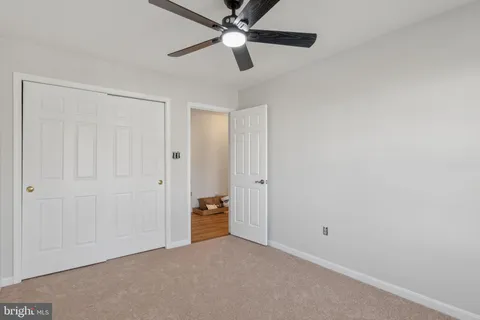 an empty room with closet and a chandelier fan