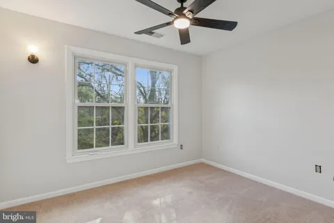 an empty room with a window and a fan