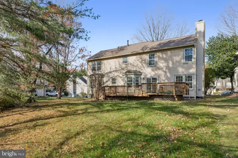 a view of swimming pool with lawn chairs and large trees