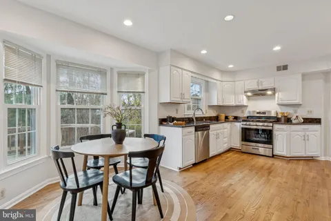 a kitchen with a table chairs microwave and cabinets