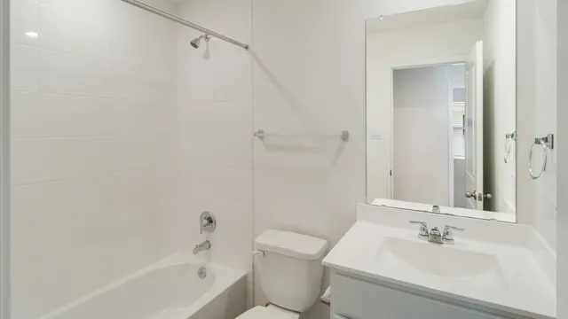 a bathroom with a bathtub shower sink vanity and toilet