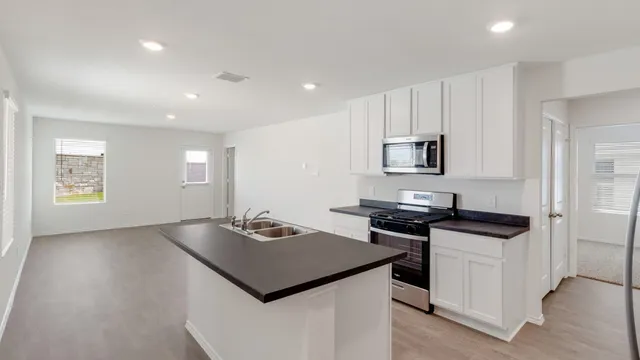 a kitchen that has a sink and a stove in it