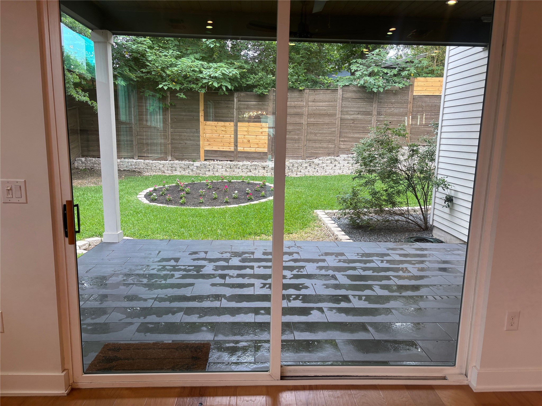 1719 Bunche Road Austin, TX 78721 - Photo 17 of 22 Sliding glass doors open to a contemporary stone patio and a verdant, fenced private yard.