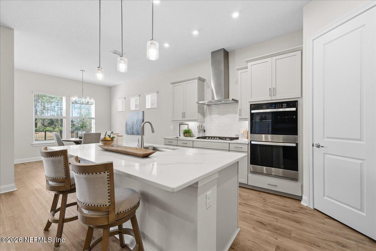 80 Ridgehill Way St. Johns, FL 32259 - Photo 14 of 60 a kitchen with stainless steel appliances kitchen island granite countertop a table chairs in it and wooden floors