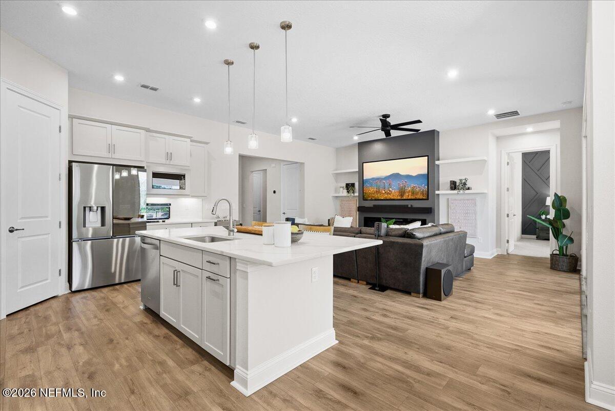 80 Ridgehill Way St. Johns, FL 32259 - Photo 18 of 60 a large kitchen with stainless steel appliances kitchen island granite countertop a large stove a refrigerator a oven and a dining table with wooden floor