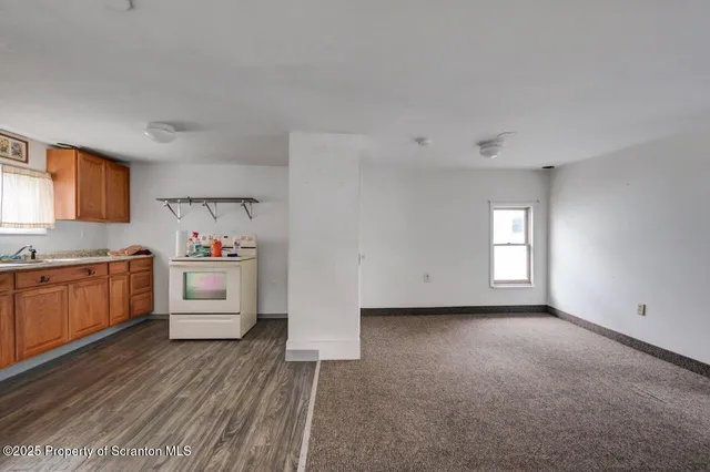 a view of a kitchen with wooden cabinet and stove top oven