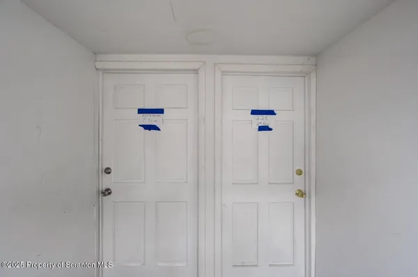 a view of a hallway with white wooden cabinets