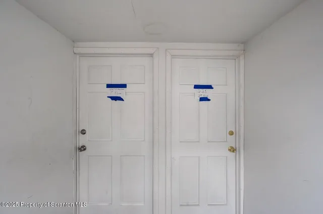 a view of a hallway with white wooden cabinets