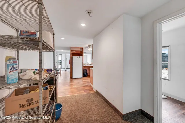 a view of a kitchen with fridge and wooden floor