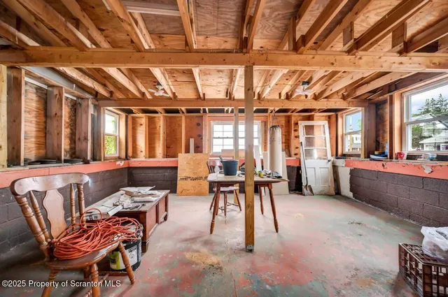 a living room with furniture a flat screen tv and windows