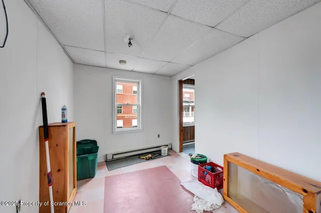 a view of a kitchen with a refrigerator and white cabinets