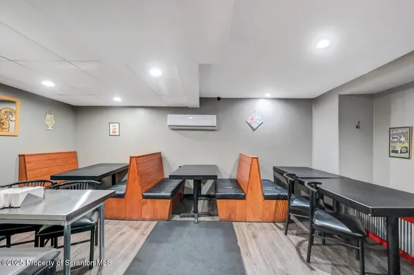 a dining room with lots of wooden furniture and a chandelier