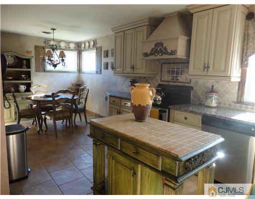 6 Lawton Road Bridgewater, NJ 08807 - Photo 12 of 25 a kitchen with a table chairs and a refrigerator