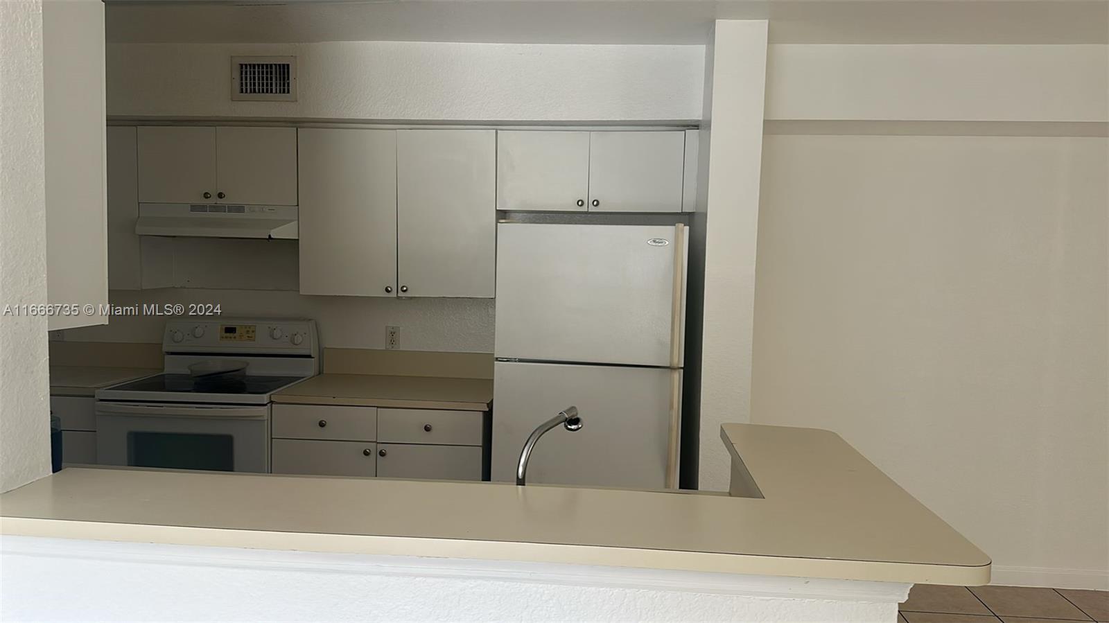 15430 Southwest 284th Street, Unit 6202 Homestead, FL 33033 - Photo 3 of 17 a kitchen with a refrigerator and white cabinets