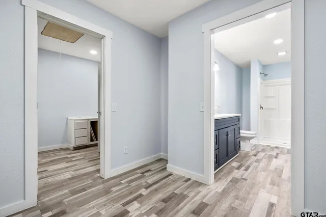 a view of a hallway with wooden floor and a living room