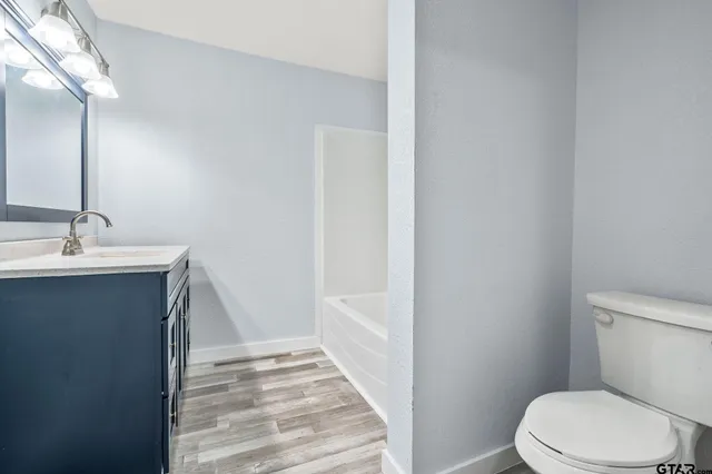 a bathroom with a white toilet sitting next to a sink