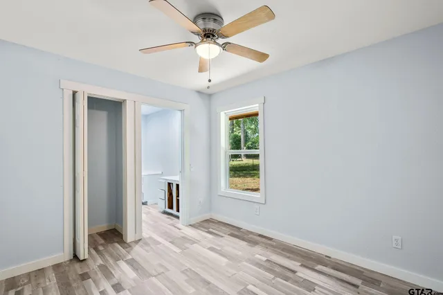 an empty room with fan and windows