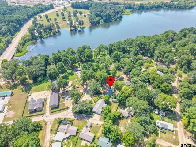 an aerial view of residential houses with outdoor space and lake view