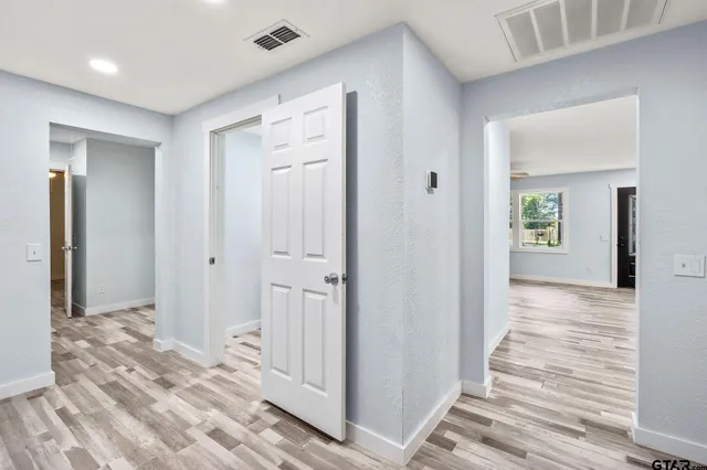 a view of a hallway with wooden floor and closet