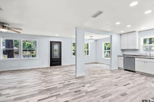 a view of an empty room with window and wooden floor